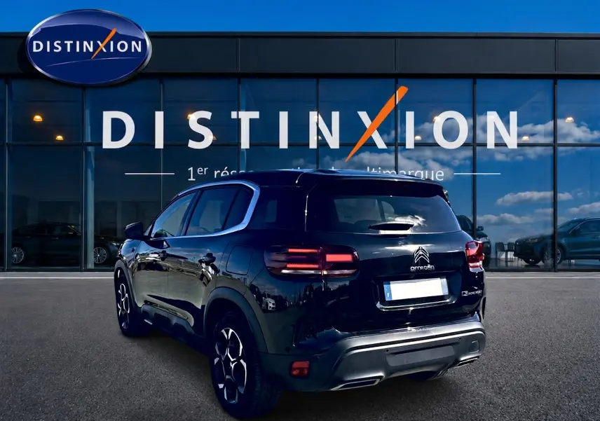 Vue 3/4 arrière droite d'un Citroën C5 Aircross noir 2024 avec feux arrière LED et jantes alliage.