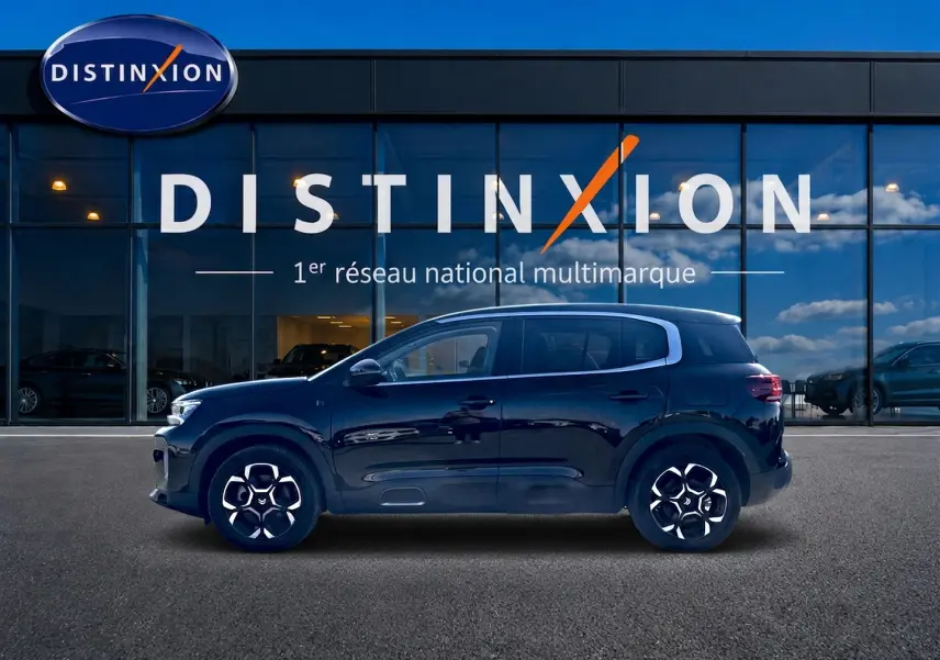 Profil côté gauche du Citroën C5 Aircross hybride rechargeable noir 2024, avec jantes alu et barres de toit visibles.
