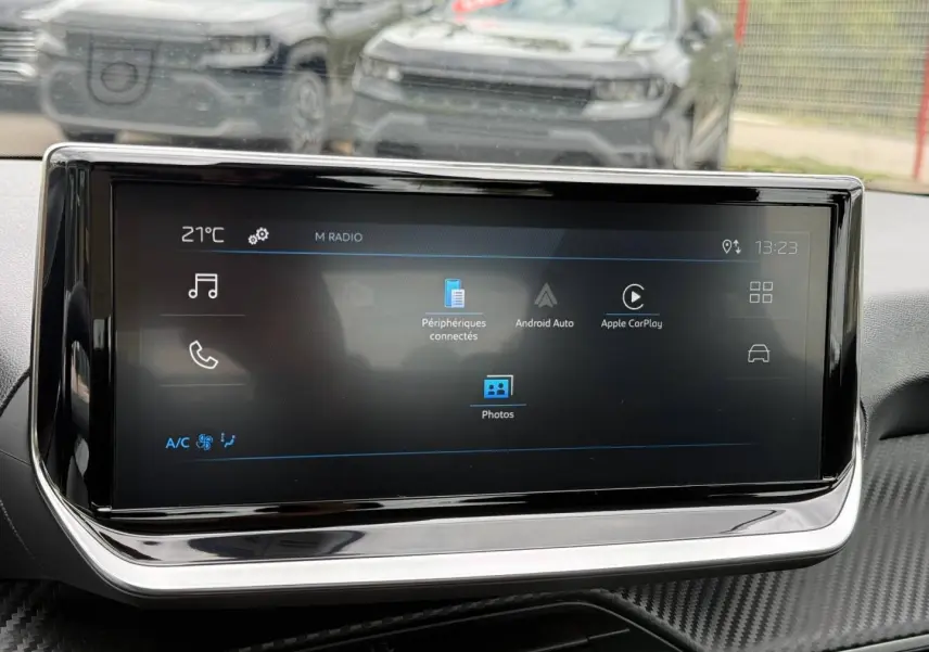 Écran tactile central du tableau de bord de la Peugeot 208 noire, affichant les options Android Auto et Apple CarPlay.