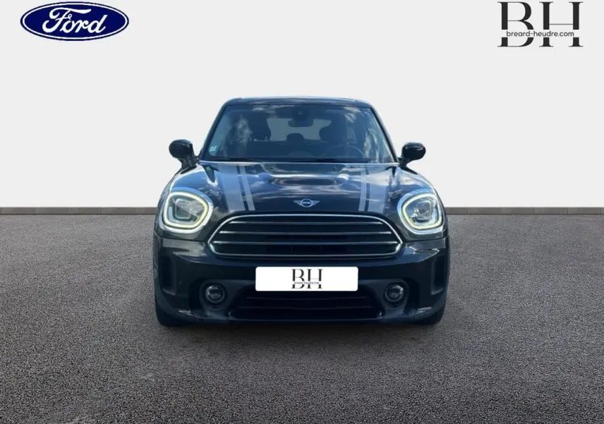 Vue avant d'une MINI Countryman Cooper D noire Midnight Black avec bandes grises sur capot et phares LED allumés.