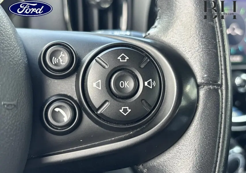Boutons de commande audio et téléphone sur le volant cuir noir d'un MINI Countryman Cooper D 2020, vue rapprochée.