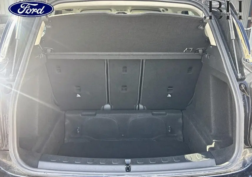 Coffre ouvert d’un MINI Countryman Midnight Black vu de l’arrière, montrant l’espace de chargement et la banquette arrière.