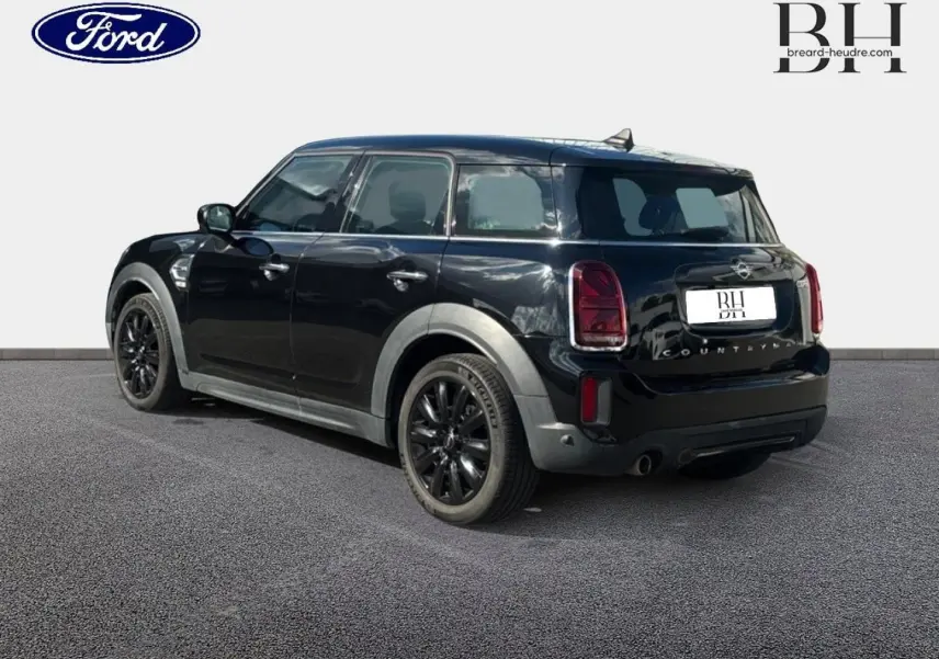 MINI Countryman Cooper D noir Midnight Black, vue 3/4 arrière droit avec jantes alu noires et bandes grises sur capot.