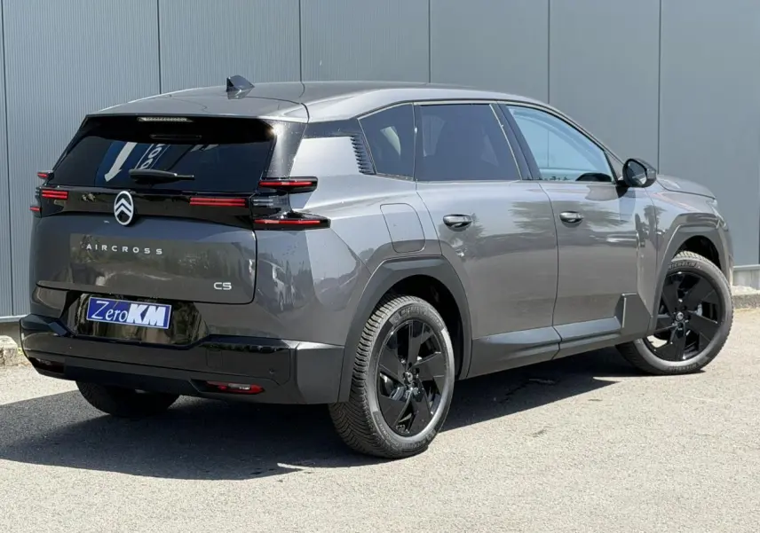 Vue 3/4 arrière droite d'un Citroën C5 Aircross gris Platinium avec jantes noires et feux arrière LED horizontaux.