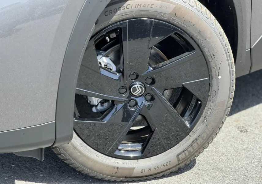 Gros plan sur la roue avant gauche du Citroën C5 Aircross gris Platinium avec jante alliage noire brillante.