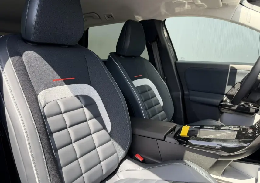 Vue intérieure des sièges avant gris et noirs avec surpiqûres blanches du Citroën C5 Aircross 2026, console centrale visible.
