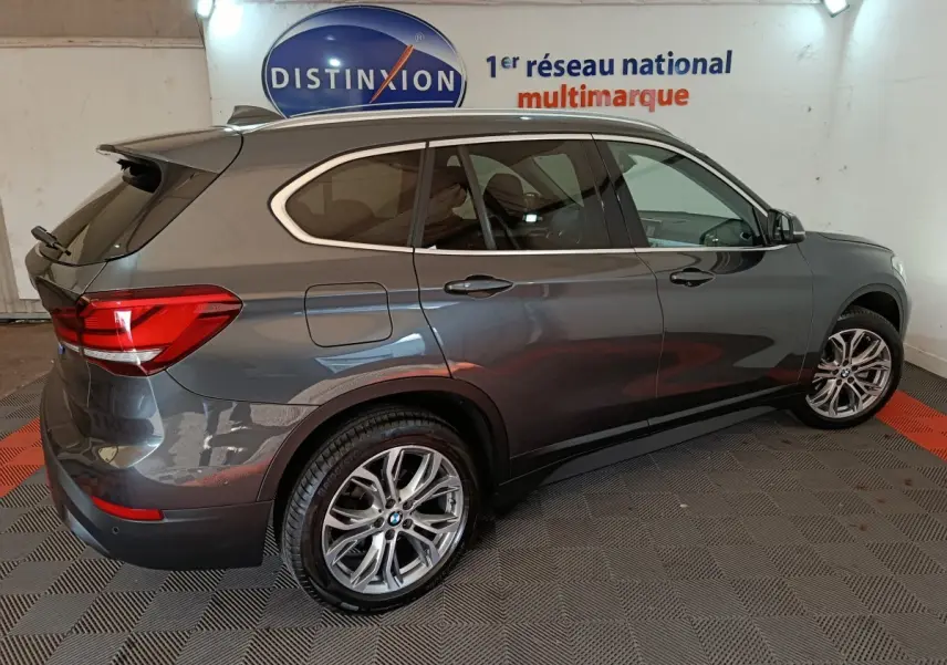 BMW X1 sDrive18i Lounge gris foncé vue de profil côté droit, avec jantes alliage et feux arrière LED visibles.