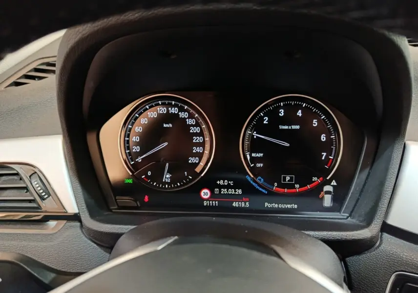 Vue rapprochée du tableau de bord numérique du BMW X1 sDrive18i Lounge 2021, affichage clair et moderne.