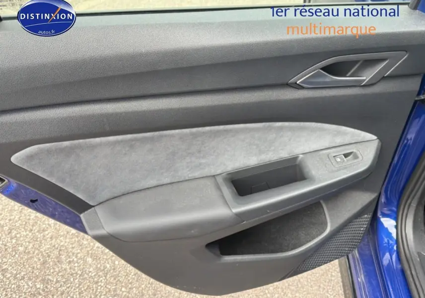 Vue rapprochée de la porte avant gauche bleu de la Volkswagen Golf 2024 avec garniture grise et commandes de vitre.