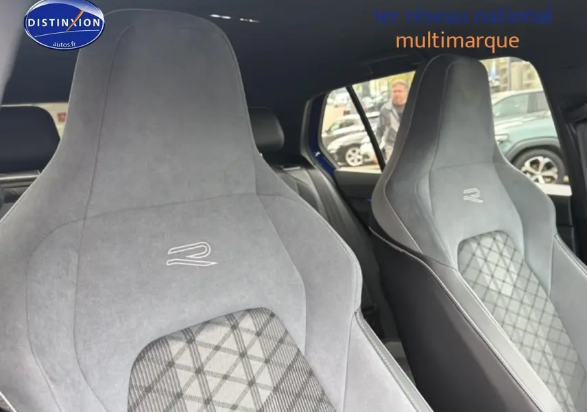 Gros plan sur les sièges avant sport gris avec logo R de la Volkswagen Golf 2024, intérieur visible côté droit.