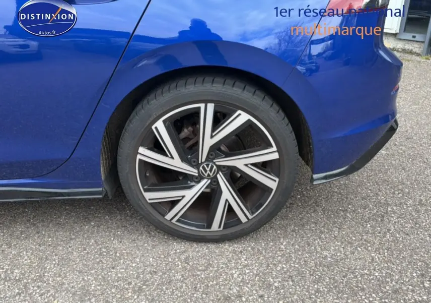 Gros plan sur la roue arrière droite et la carrosserie bleue d'une Volkswagen Golf 2024 finition R-Line.