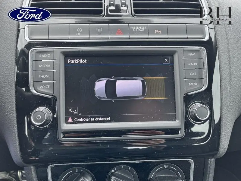 Vue rapprochée de l’écran tactile central noir affichant le système ParkPilot dans une Volkswagen Polo noire de 2017.