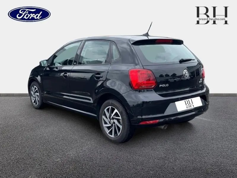 Vue 3/4 arrière droite d'une Volkswagen Polo noire unie avec jantes alliage et feux arrière rouges visibles.