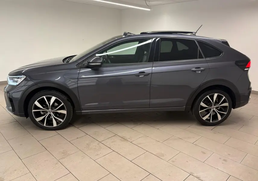 Volkswagen Taigo gris cendré vue de profil côté gauche, avec jantes noires brillantes et toit ouvrant électrique.