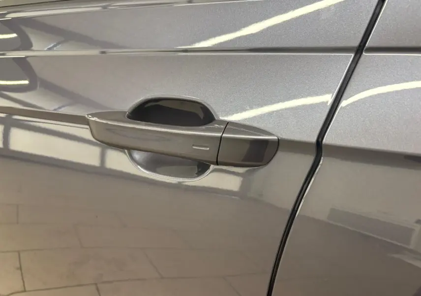 Poignée de porte côté gauche du Volkswagen Taigo gris cendré métallisé, vue rapprochée sur la finition lisse.