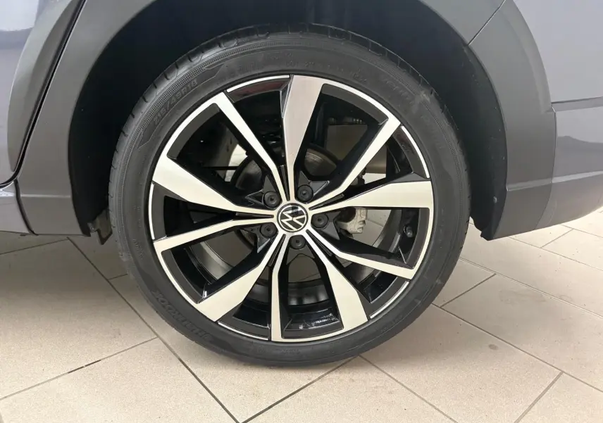 Gros plan sur la jante alliage noir et argent 18 pouces du côté gauche du Volkswagen Taigo gris cendré.