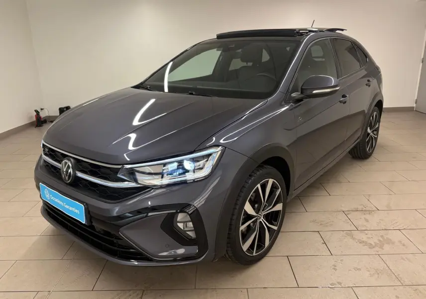Volkswagen Taigo gris cendré en 3/4 avant droit, avec jantes noires brillantes et toit ouvrant électrique.