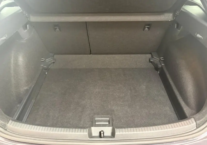 Coffre ouvert du Volkswagen Taigo gris cendré, montrant un espace de chargement propre et bien fini.