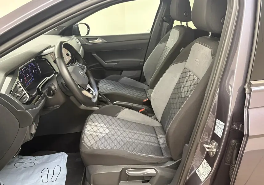 Vue intérieure côté conducteur du Volkswagen Taigo gris cendré, sièges avant en tissu et alcantara avec surpiqûres R-Line.