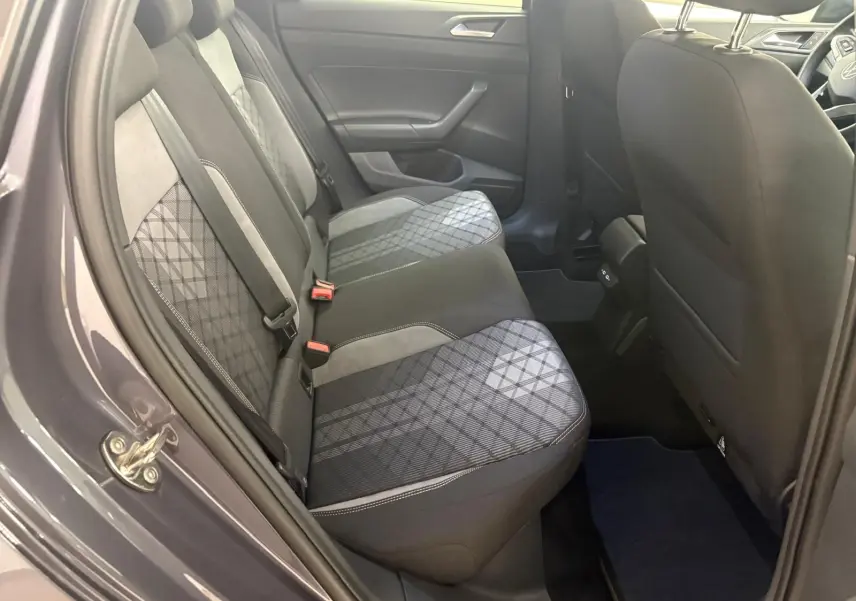 Vue côté gauche sur l'arrière du Volkswagen Taigo gris cendré, montrant les sièges arrière en tissu à motif géométrique.
