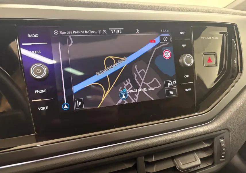 Écran tactile central du Volkswagen Taigo 2024 affichant la navigation, entouré de commandes noires brillantes.