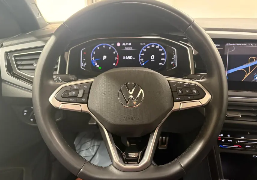 Vue intérieure centrée sur le volant noir du Volkswagen Taigo 2024 avec tableau de bord digital et écran tactile.