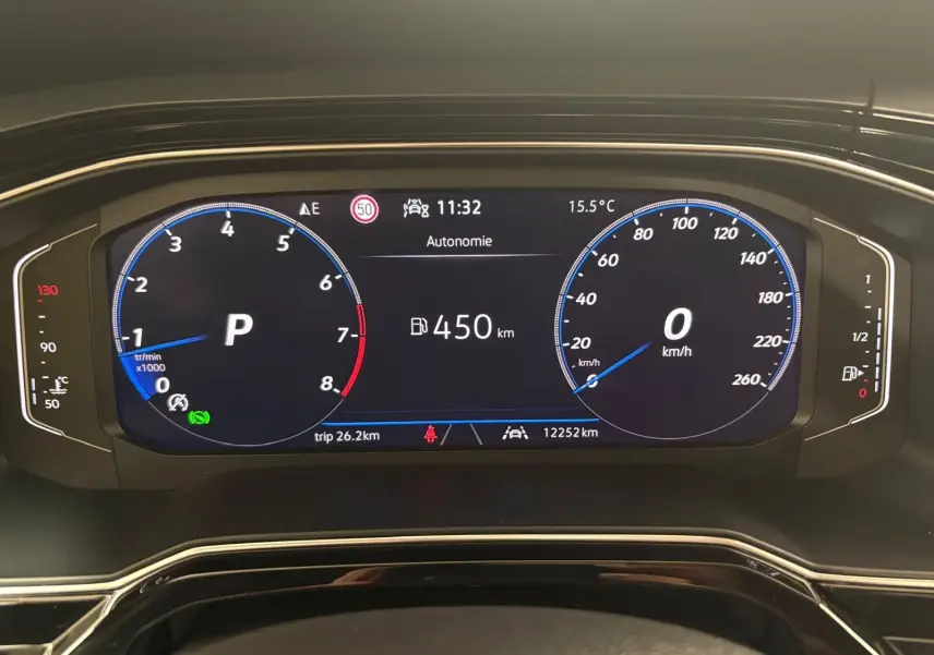 Tableau de bord numérique du Volkswagen Taigo 2024 affichant vitesse, régime moteur et autonomie, vue frontale rapprochée.