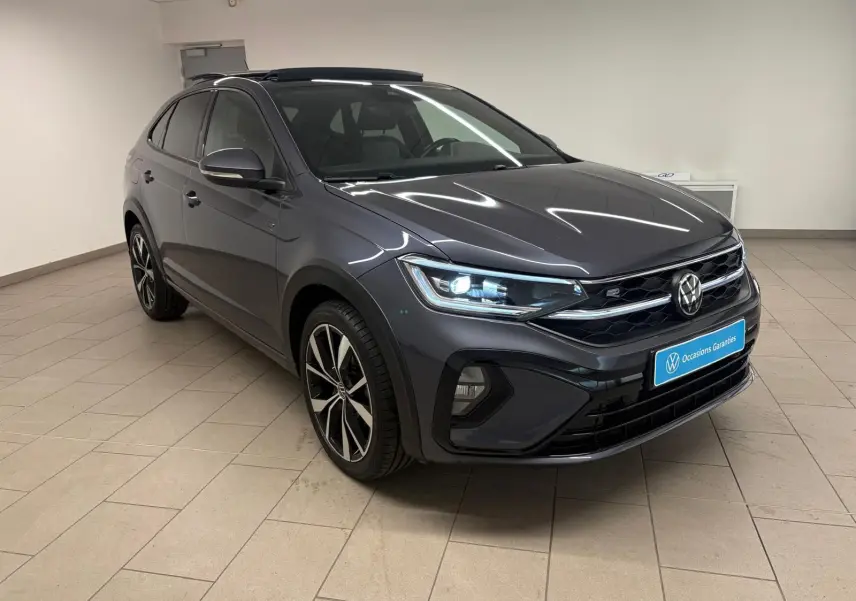 Volkswagen Taigo 1.5 TSI R-Line gris cendré en 3/4 avant droit avec toit ouvrant et jantes noires brillantes.