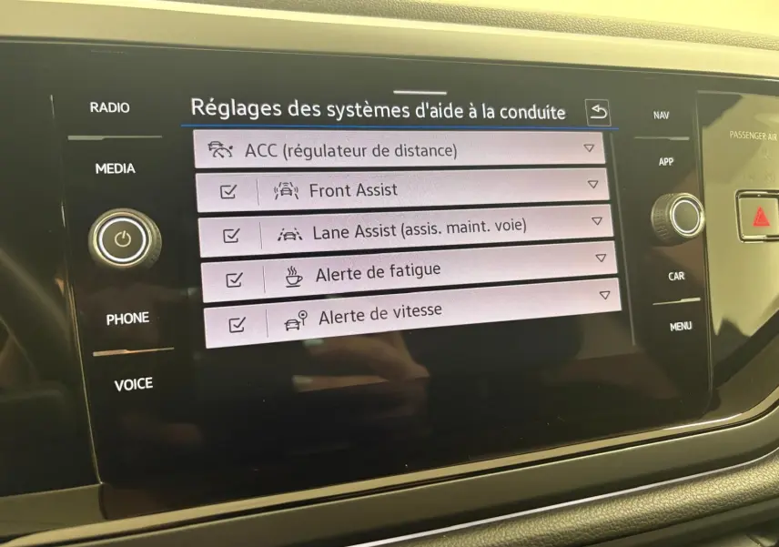 Écran tactile du système d'aide à la conduite du Volkswagen Taigo 2024 affichant les réglages d'assistances activées.