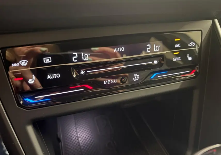Panneau de commande de la climatisation automatique du Volkswagen Taigo 2024 avec réglages à 21°C et sièges chauffants.