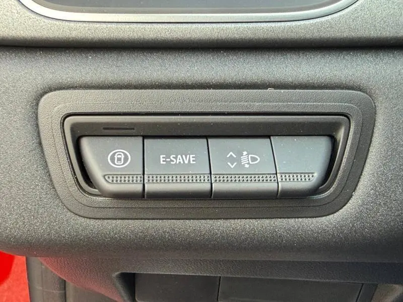 Gros plan sur les boutons de commande E-SAVE et réglage des phares dans un Renault Captur rouge 2025.