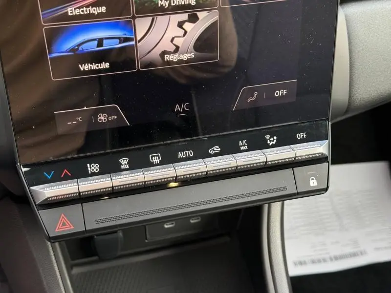 Gros plan sur la console centrale tactile du Renault Captur 2025 rouge, montrant les commandes climatisation et multimédia.