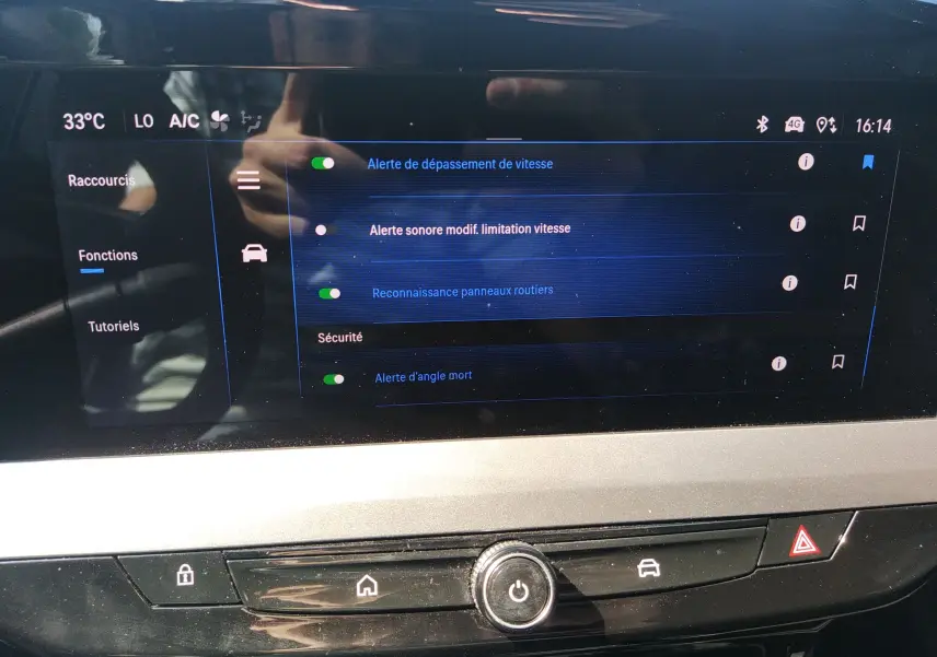 Écran tactile intérieur de l’Opel Mokka Electric gris 2025 affichant les réglages d’alerte de sécurité et de reconnaissance des panneaux.