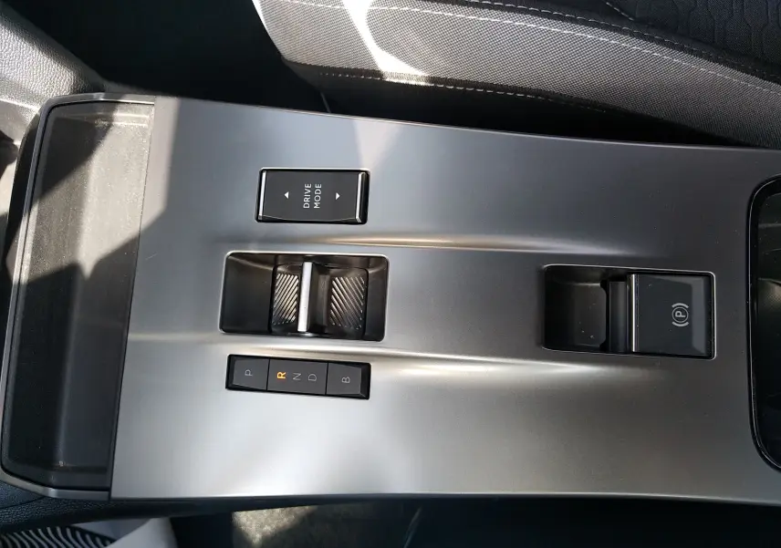 Vue rapprochée de la console centrale grise de l’Opel Mokka Electric 2025 avec commandes de boîte auto et frein à main électrique.