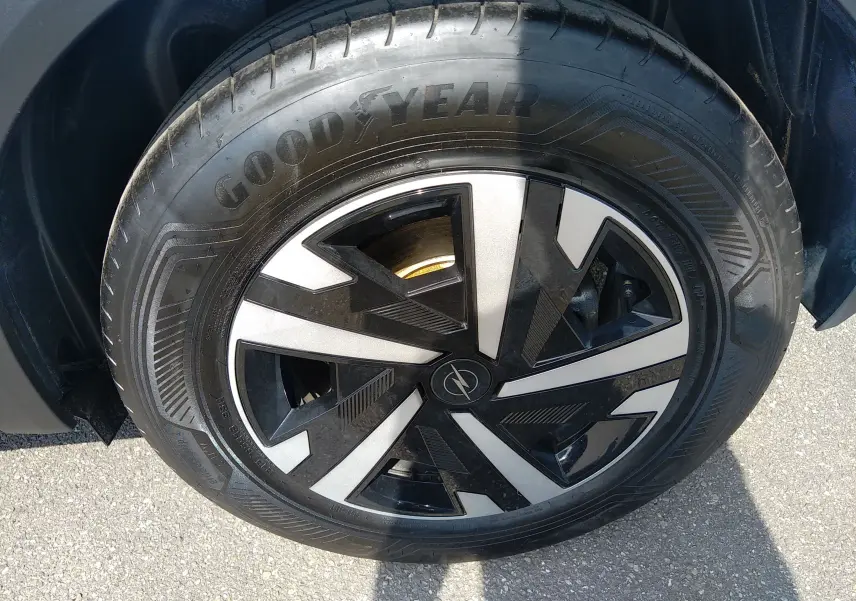 Gros plan sur la roue avant droite de l'Opel Mokka Electric gris, avec jante noire et argent et pneu Goodyear.