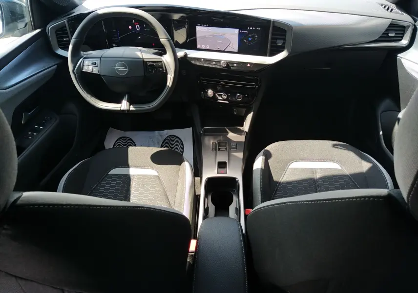 Intérieur de l’Opel Mokka Electric gris, vue avant centrée sur le tableau de bord numérique et l’écran tactile GPS.