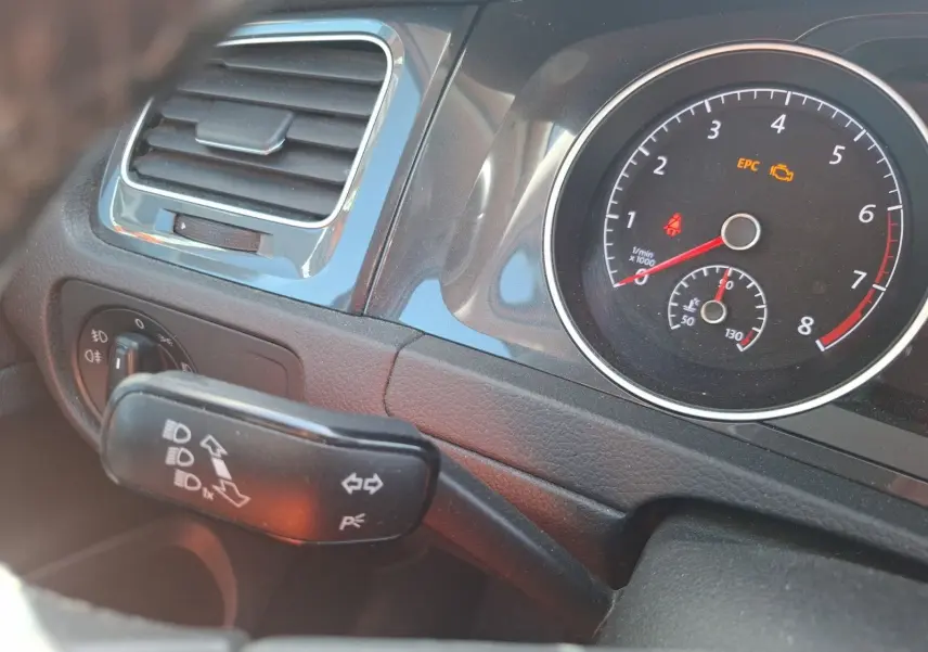 Détail du tableau de bord côté gauche de la Volkswagen Golf blanche 2019, avec compte-tours et commandes d'éclairage visibles.