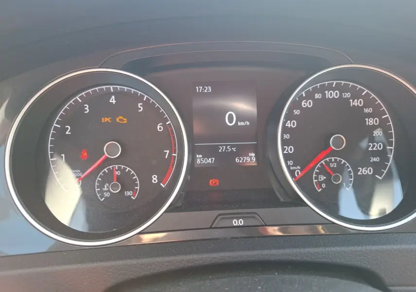 Vue rapprochée du tableau de bord de la Volkswagen Golf blanche, affichant le compteur et l'ordinateur de bord.