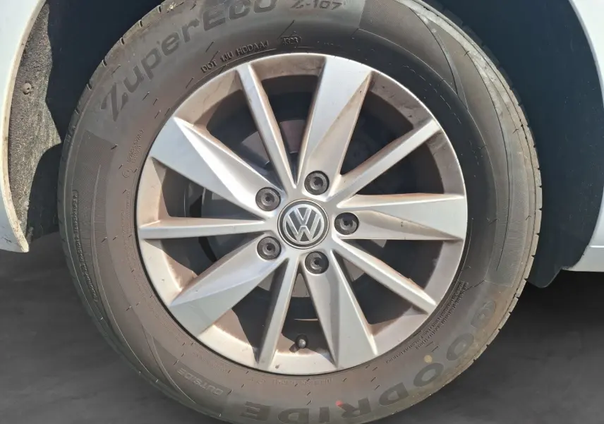 Gros plan sur la jante alliage argentée d'une Volkswagen Golf blanche, mettant en valeur le logo VW central.