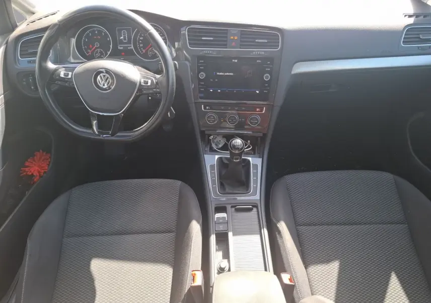 Vue intérieure avant de la Volkswagen Golf 2019, tableau de bord noir avec volant multifonction et boîte manuelle.
