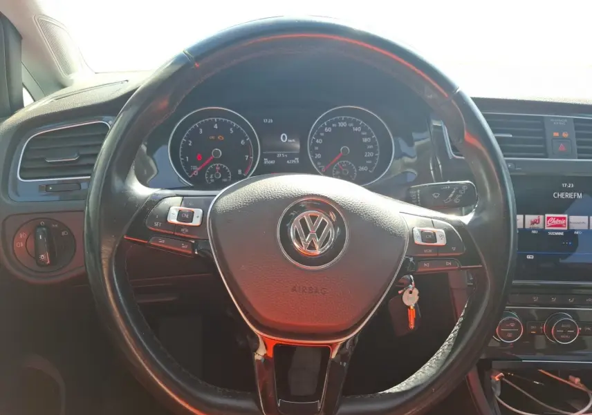 Vue rapprochée du volant noir de la Volkswagen Golf 2019 avec tableau de bord et écran tactile visible.
