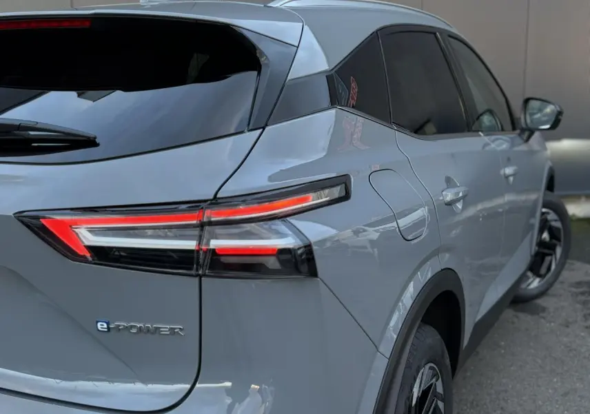 Vue 3/4 arrière droite du Nissan Qashqai 2025 gris Ceramic avec feux arrière LED et badge e-POWER visible.