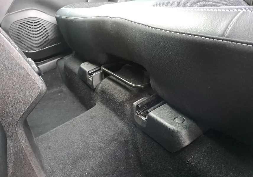 Gros plan sous le siège arrière côté droit du Renault Captur 1.3 TCE 140 Intens 2022, intérieur noir.