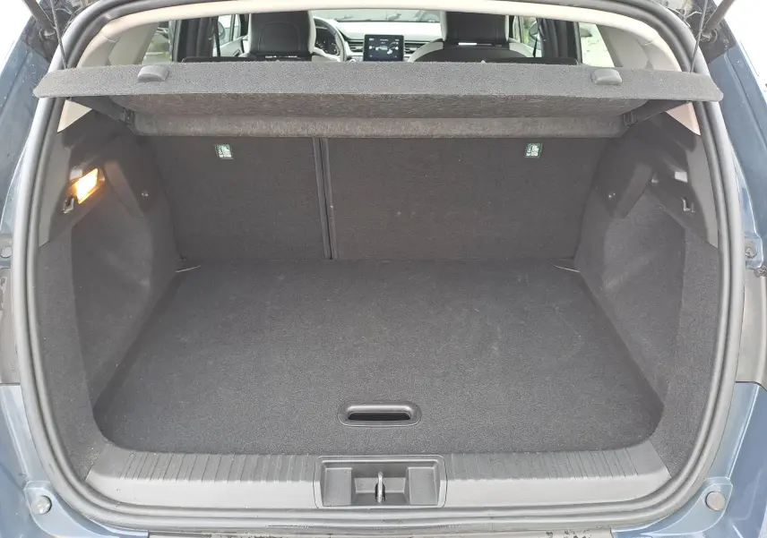 Coffre ouvert vu de l'arrière d'un Renault Captur bleu marine 2022, montrant un espace de chargement vide et propre.