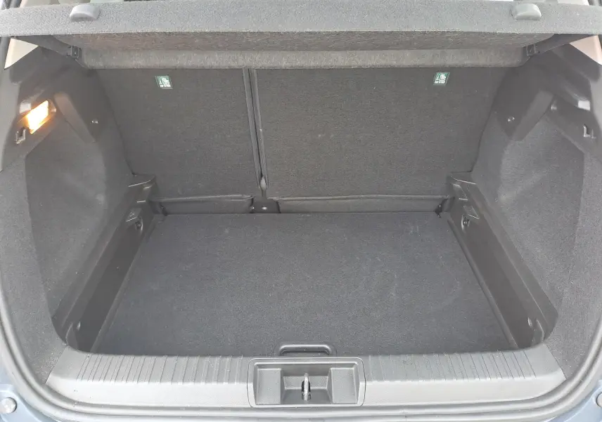 Coffre ouvert vu de l'arrière d'un Renault Captur bleu marine 2022, espace de chargement vide et propre.