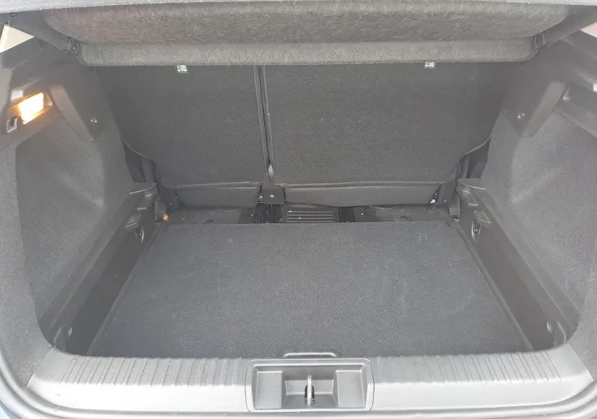 Coffre vide vu de face du Renault Captur bleu marine 1.3 TCE 140 INTENS EDC 2022 avec éclairage intérieur à gauche.