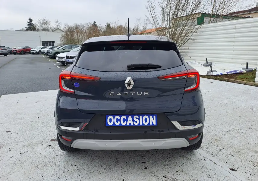 Vue arrière d'un Renault Captur bleu marine 2022 avec feux LED allumés et plaque "OCCASION" visible.