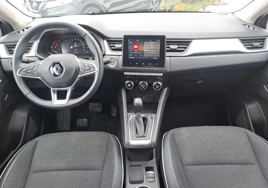 Vue intérieure avant du Renault Captur 1.3 TCE 140 Intens 2022, tableau de bord noir avec écran tactile central et volant multifonction.