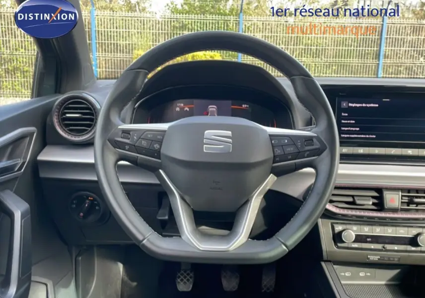 Vue centrée sur le volant noir de la SEAT Ibiza 2025, avec tableau de bord digital et console centrale moderne.