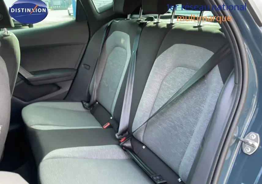 Vue côté droit sur l'intérieur arrière d'une SEAT Ibiza 2025 bleu fjord avec sièges tissu bicolores gris et noir.